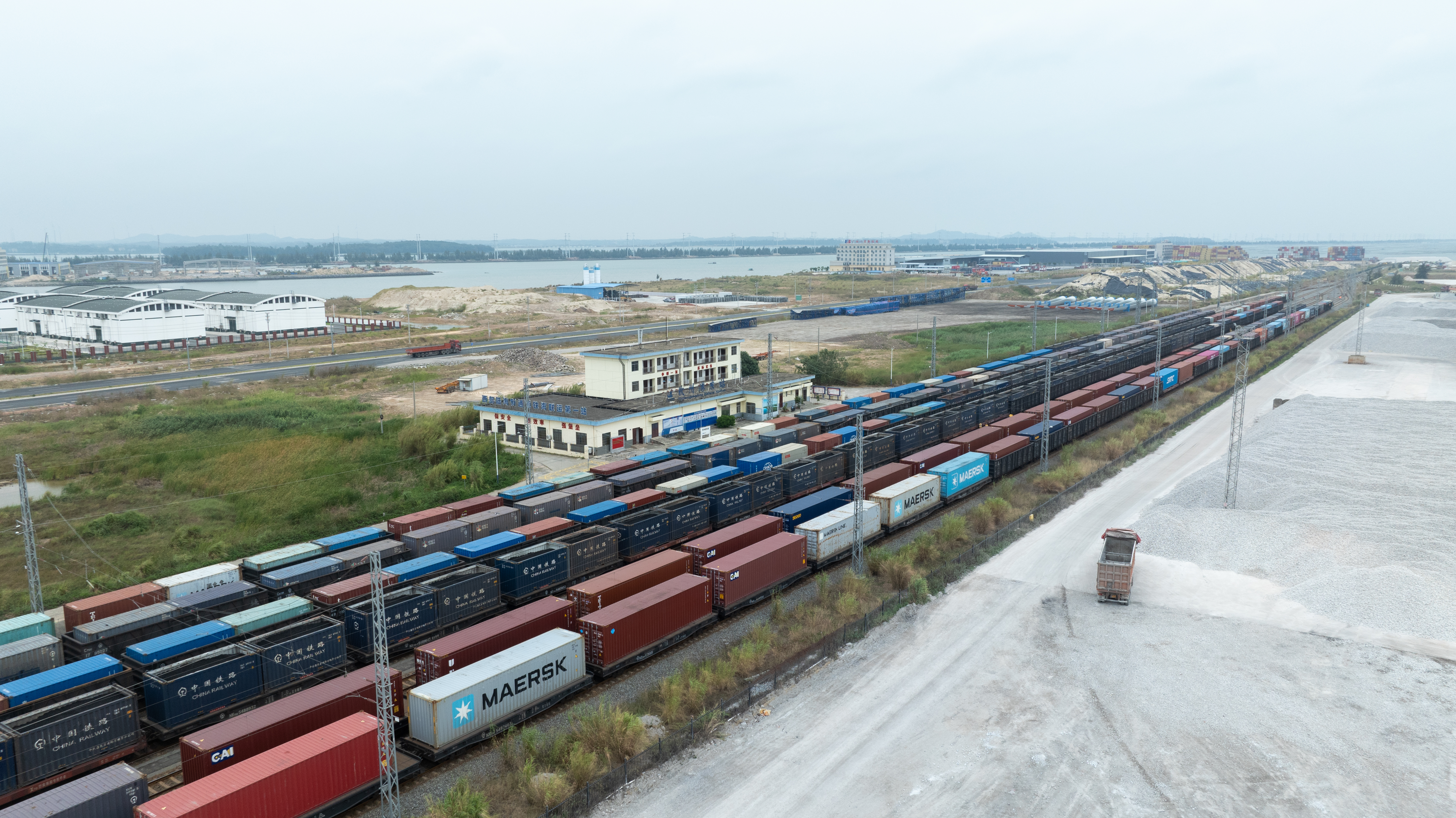 图为11月4日,在广西繁忙的钦州港东站,多台满载集装箱货物的班列整齐停靠在站场内等待发车。陈磊 摄