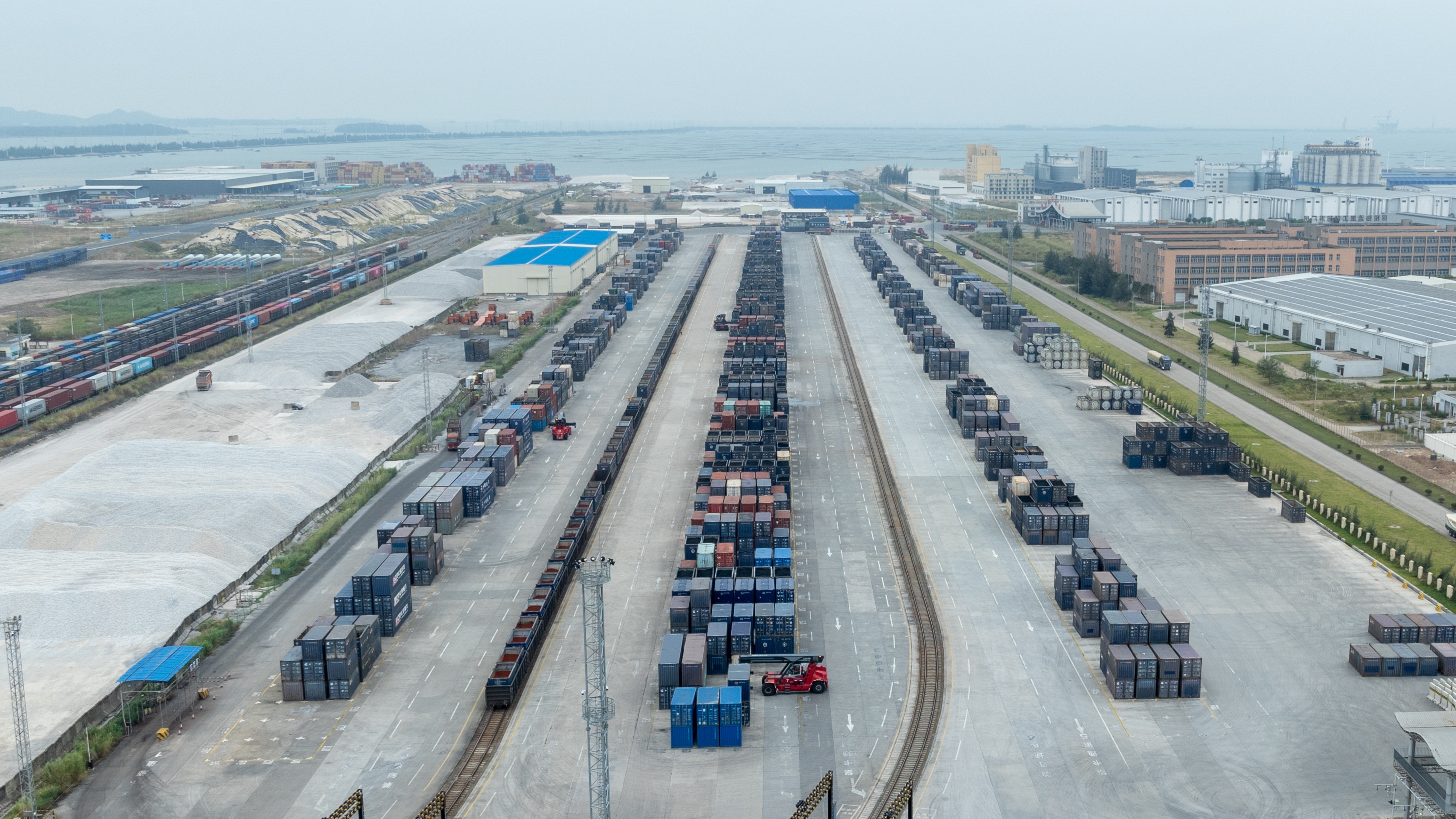 图为11月4日,广西钦州铁路集装箱中心站作业场内,正面吊机正在进行装卸作业。何家海摄